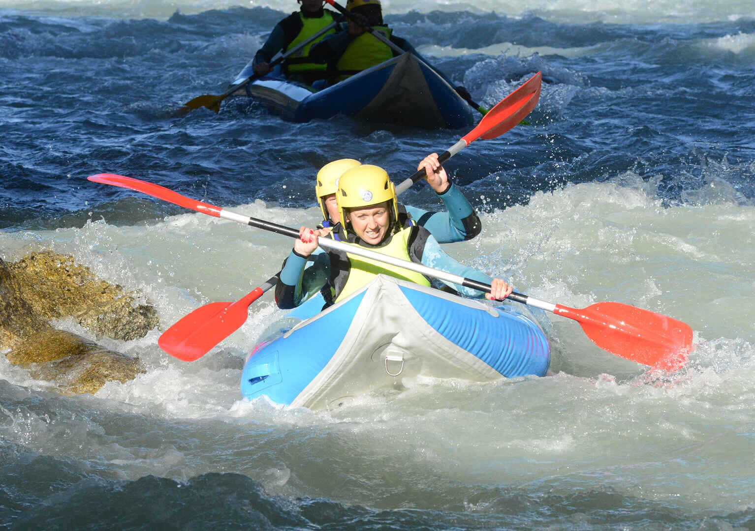 2 people canoe rafting on a river