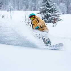 A girl snowboarding in deep snow