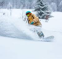 A girl snowboarding in deep snow