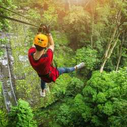 A boy zip lining in the forest