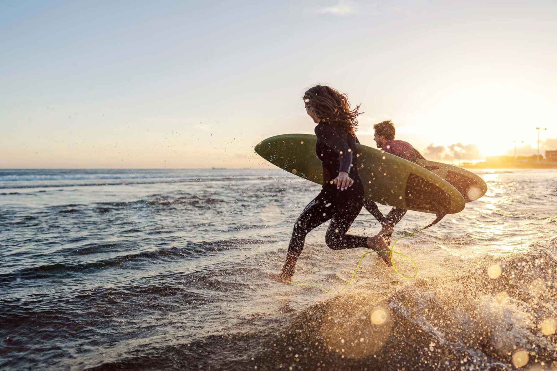 Surfers running into the sea