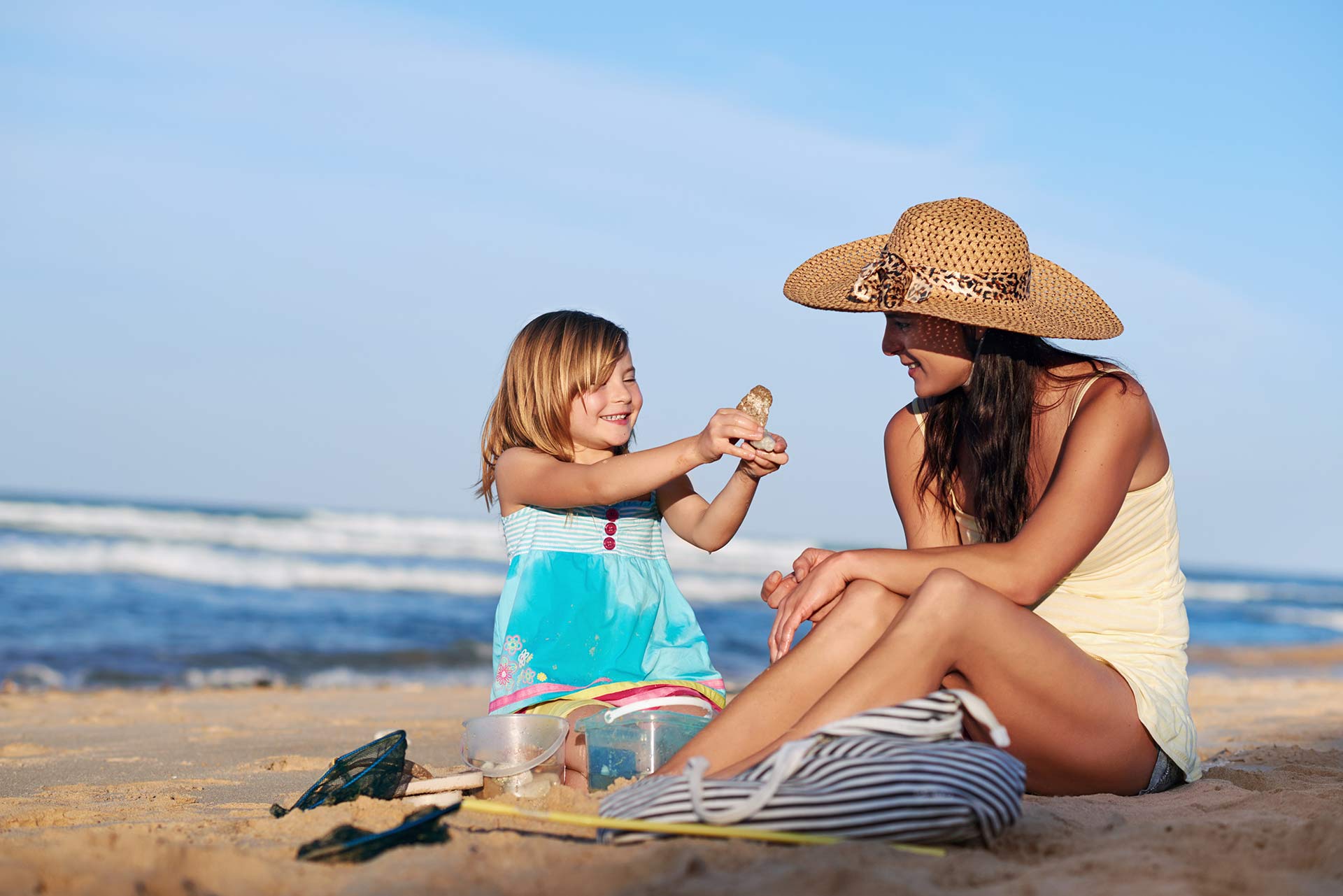 mother and daughter sitting on a beach