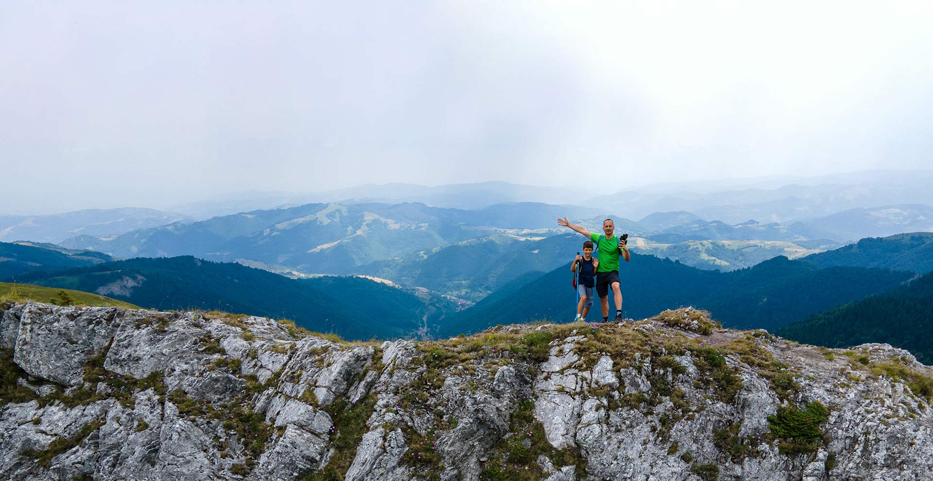 father and son standing on a mountain ridge