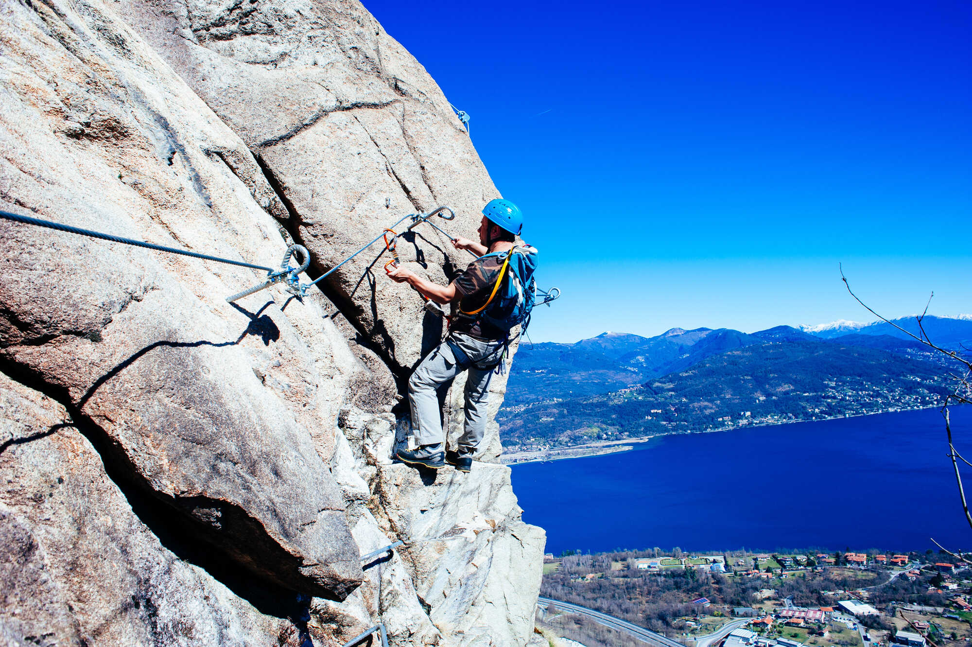 image showing a person climbing a steel ladder on a cliff face